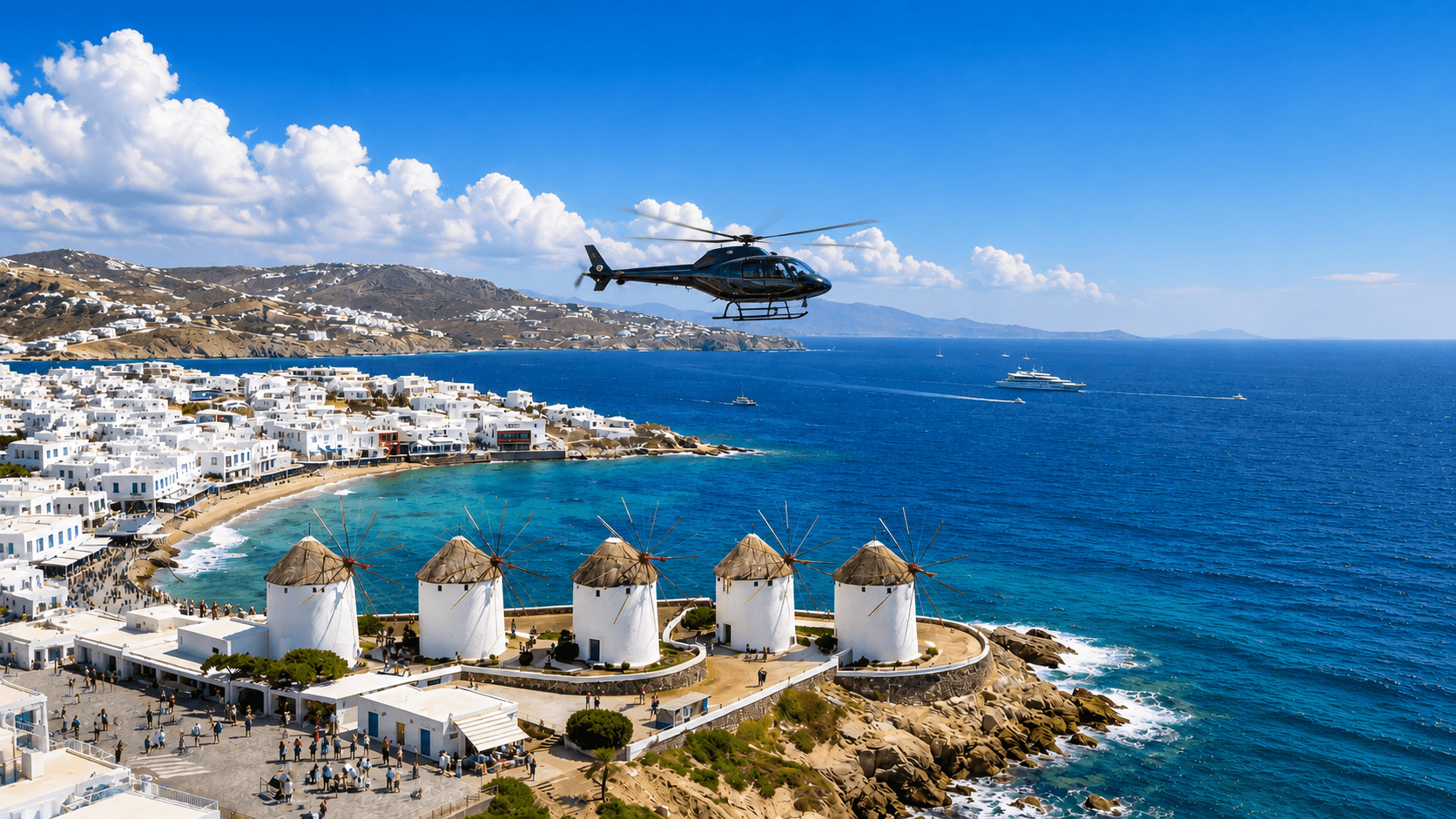 Helicopter flying over the Mykonos windmills and Little Venice waterfront